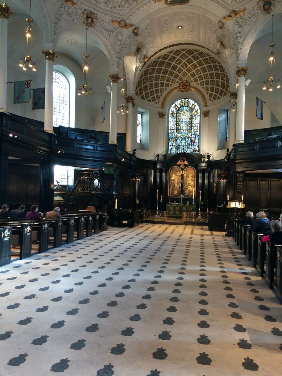 Interior of St Clement Danes, the Central Church of the Royal Air Force, with squadron badges set into the floor and standards hanging above